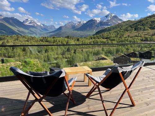 two chairs on a deck with mountains in the background at Exclusive Fjord Lodge with Private Jacuzzi and Epic Views in Lii