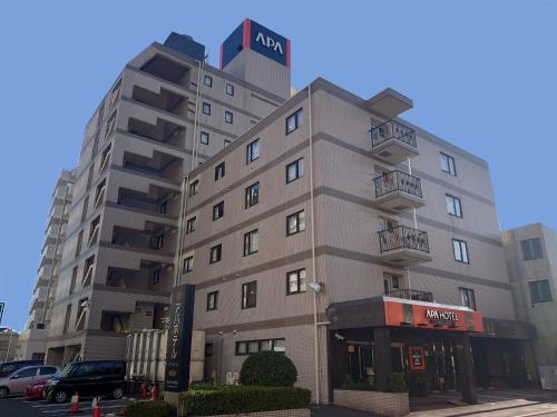 a tall building with a sign on top of it at APA Hotel Isehara-Ekimae in Isehara