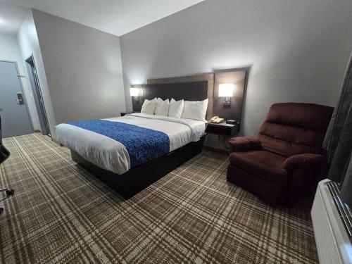 a hotel room with a bed and a chair at GrandStay Hotel & Suites Minocqua in Minocqua