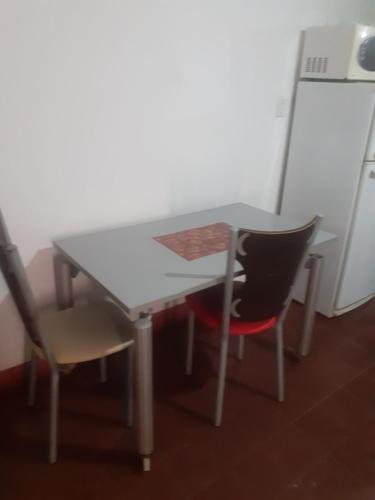 Una mesa y dos sillas sentadas al lado de una mesa. en Departamento Monoambiente, en La Rioja