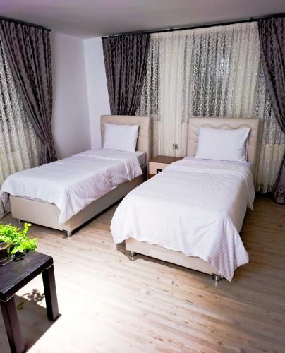 a bedroom with two beds and a table at Cappadocia Beyaz Konak 1 in Gülşehir