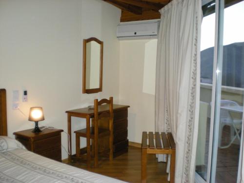 a bedroom with a bed and a desk and a mirror at Labella María in Pinos Genil