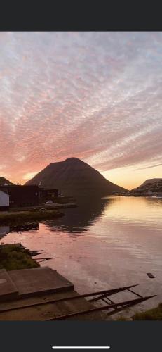 a view of a body of water with a mountain at Small renovated boathouse down by the sea in Klaksvík