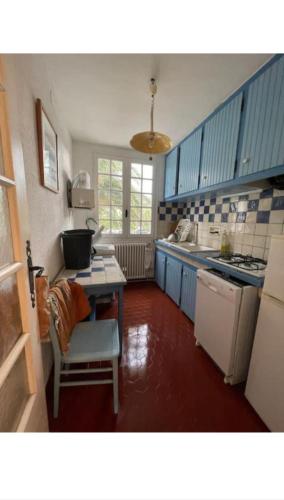 d'une cuisine avec des placards bleus et une table. dans l'établissement Racou Maison front de Mer, à Argelès-sur-Mer