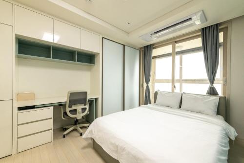 a bedroom with a bed and a desk and a chair at The November Stay In landmark in Incheon