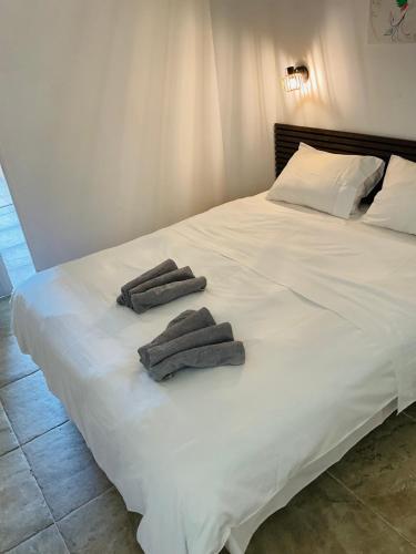 a white bed with two towels on top of it at Appartement in Baie Nettle
