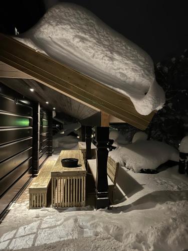 a snow covered table and benches in the snow at Exclusive Fjord Lodge with Private Jacuzzi and Epic Views in Lii