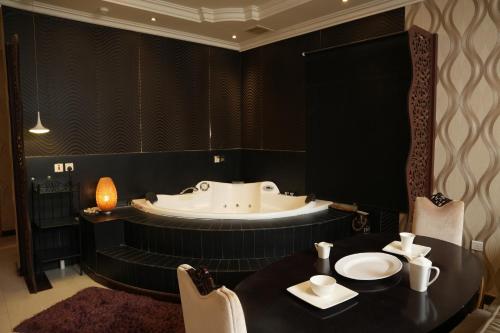 a bathroom with a tub and a table and chairs at ELGOUN Serviced apartments in Riyadh