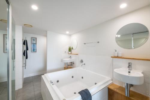 Un baño blanco con bañera y lavabo. en Turquoise Shores Whitsundays, en Airlie Beach