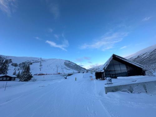 a snow covered slope with a building in the distance at Exclusive Fjord Lodge with Private Jacuzzi and Epic Views in Lii
