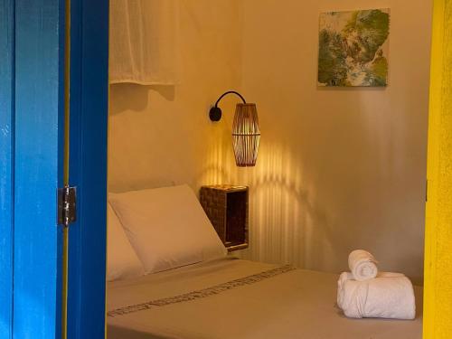 a small room with a bed and a lamp at Vila Coco Dendê - Algodões in Marau