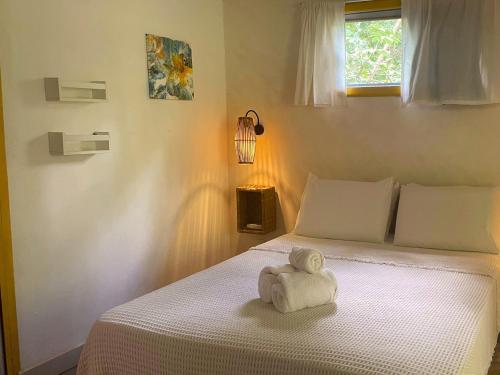 a white stuffed teddy bear sitting on a bed at Vila Coco Dendê - Algodões in Marau