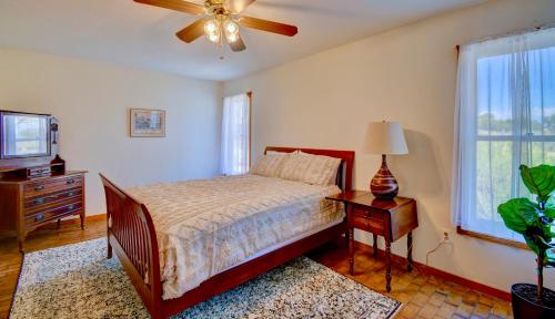 a bedroom with a bed and a ceiling fan at El Ranchito Alegre Taos-Style 3BR in Corrales in Corrales