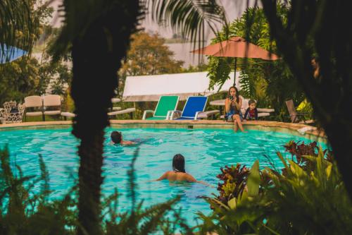 a group of people sitting in a swimming pool at Hotel Toliman in San Lucas Tolimán