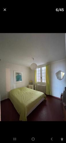 une chambre avec un lit vert et une fenêtre dans l'établissement Racou Maison front de Mer, à Argelès-sur-Mer