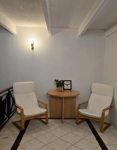 two chairs and a table in a room at Affordable & cosy, close to train station, CBD & Airport in Perth