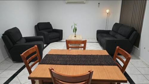 a living room with a table and chairs and a couch at Affordable & cosy, close to train station, CBD & Airport in Perth