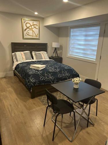 a bedroom with a bed and a table and chairs at Spacious one Bedroom Suite Right in Downtown ! in Maple Ridge District Municipality