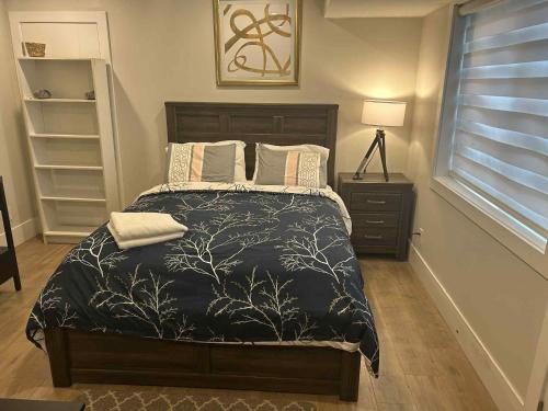 a bedroom with a bed with a black comforter at Spacious one Bedroom Suite Right in Downtown ! in Maple Ridge District Municipality