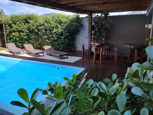 a patio with a pool and chairs and a table at casa vô Minga in Penha
