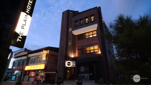 a tall building with lit windows on a city street at The Plain Hotel Dongyang in Okcheon