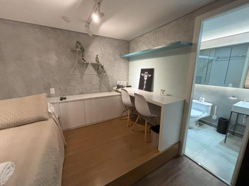Un dormitorio con una cama, una mesa y una bañera. en MLA Flat Hotel Moema Ibirapuera - Completo e ótima localização, en São Paulo