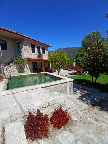 a house with a swimming pool in a yard at Villa Dos Santos - Gerês Country House in Geres