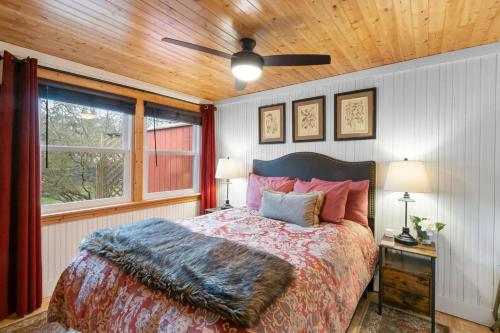 a bedroom with a bed and a ceiling fan at Cozy Cottages Red Cottage Hot tubTown in Saugatuck