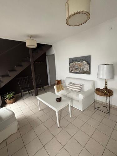 ein Wohnzimmer mit einer weißen Couch und einem Tisch in der Unterkunft LA MATRA a in Villa Luzuriaga