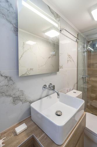 a white bathroom with a sink and a shower at Casa Mare2 in Ayia Evfimia