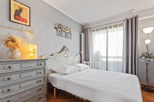 une chambre avec un lit blanc et une commode dans l'établissement Le Sémaphore - Spacious - Sea view - AC - Parking, à Antibes