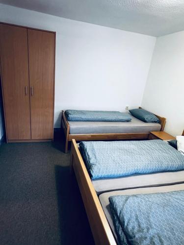 a room with three beds and a cabinet at Apart Cobras Jajce in Jajce