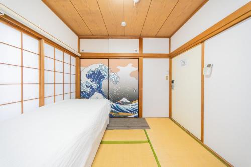 a bedroom with a painting on the wall at Ikebukuro no Yado detached house in Tokyo