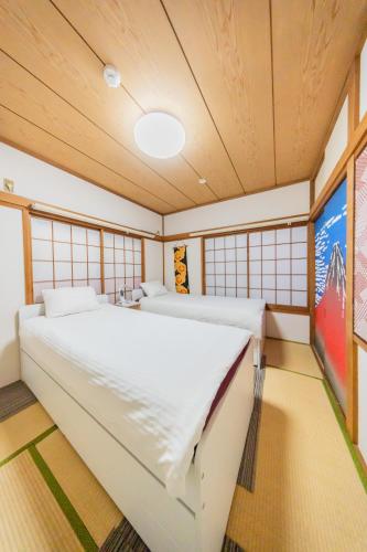 a bedroom with a large bed in a room with windows at Ikebukuro no Yado detached house in Tokyo