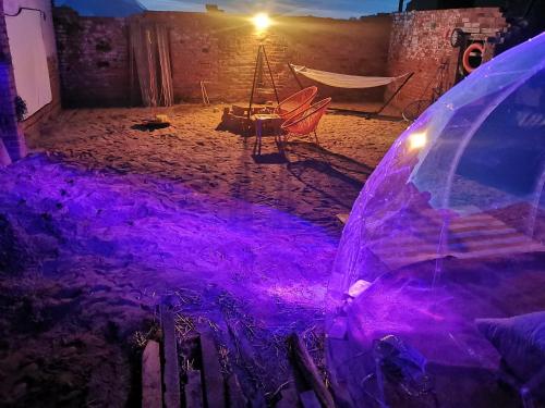 Una habitación con una hamaca y luces moradas. en Beachlife Dome with Hut & Hot Tub in Private Courtyard, en Snelland