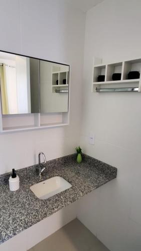 a bathroom counter with a sink and a mirror at Lindo Studio Aconchegante no Ingá in Niterói