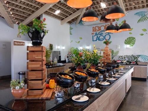 une ligne de buffet avec des bols de nourriture et des plantes dans l'établissement Resort do Lago consulte dias disponíveis, à Caldas Novas
