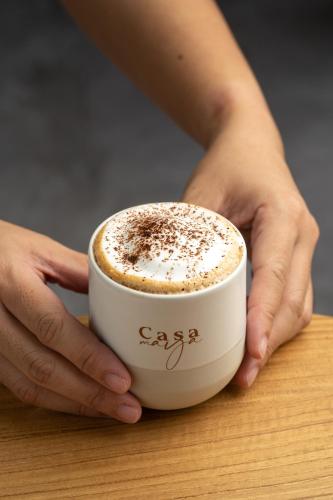 a person holding a cup of coffee on a table at Ton Sai Tropical Phi Phi Island in Phi Phi Don