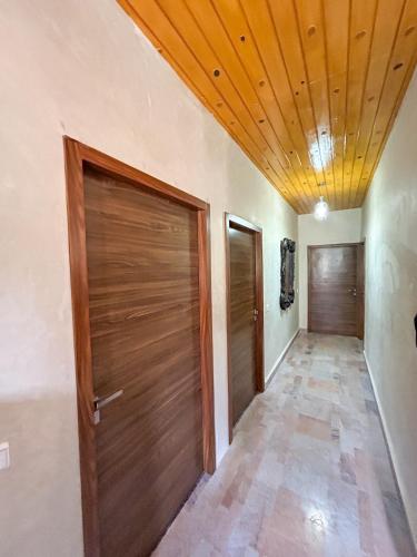 a hallway with two doors and a wooden ceiling at Blue Atlas Villa in Igrif Foudene