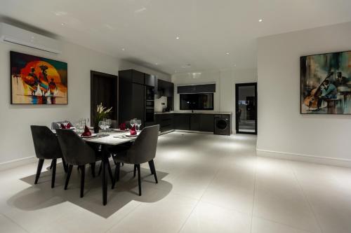 a kitchen and dining room with a table and chairs at The VVS Apartments in Accra