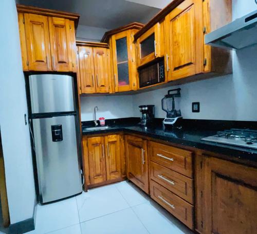 a kitchen with wooden cabinets and a refrigerator at casa borde de lago in Panajachel