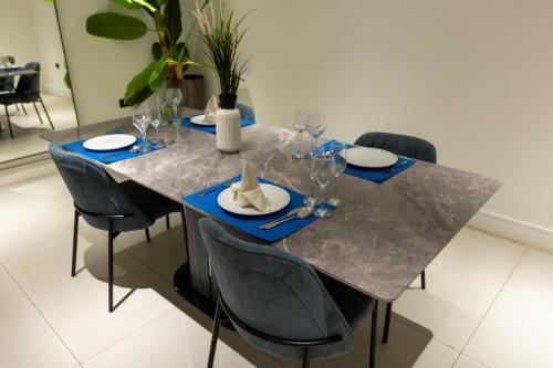 a dining room table with chairs and a gray tablecloth at The VVS Apartments in Accra