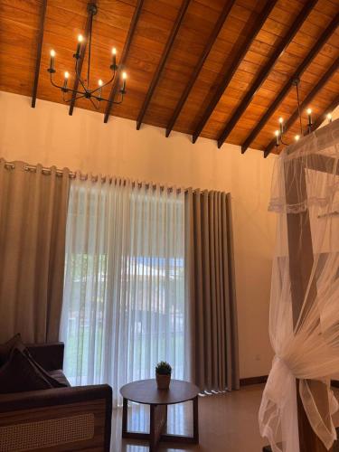 a living room with a table and a large window at Swanee Grand in Negombo