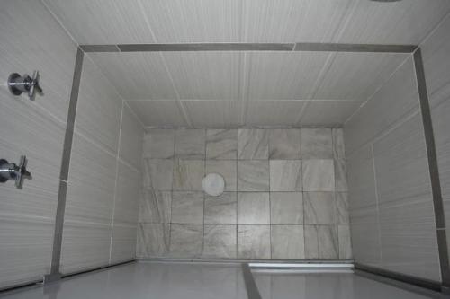 eine Dusche mit einer Steinmauer in einem Zimmer in der Unterkunft B - Céntrico Loft Privado - Alegría Housing in Aguascalientes