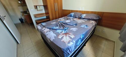 Una cama con un edredón colorido en un dormitorio. en Apartamento 515 serra park esplanada, en Rio Quente