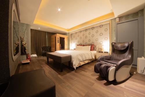 a hotel room with a bed and a chair at Wsb Motel-Rende in Tainan