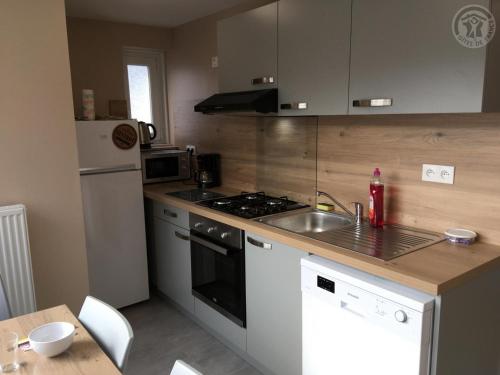 a kitchen with a sink and a stove top oven at Maison Douaisis pour 4 pers avec jardin, terrasse, parking sécurisé et proche tramway - FR-1-510-134 in Aniche
