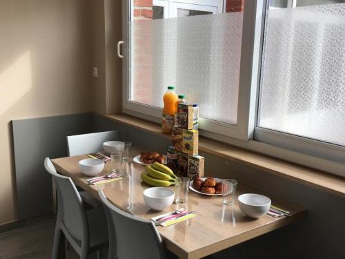 a table with plates of food and fruit on it at Maison Douaisis pour 4 pers avec jardin, terrasse, parking sécurisé et proche tramway - FR-1-510-134 in Aniche