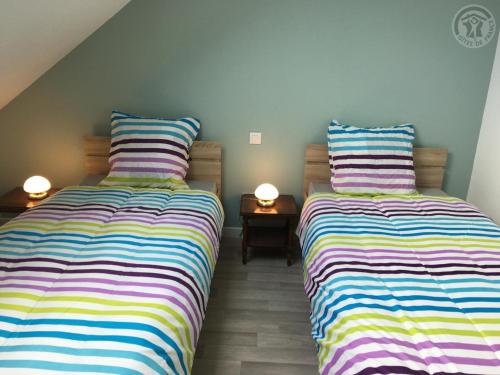 two beds sitting next to each other in a room at Maison Douaisis pour 4 pers avec jardin, terrasse, parking sécurisé et proche tramway - FR-1-510-134 in Aniche