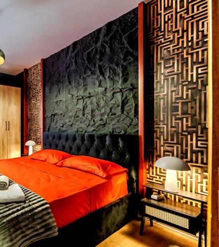 a bedroom with a red bed and a stone wall at Premium Beachfront Residences in Durrës